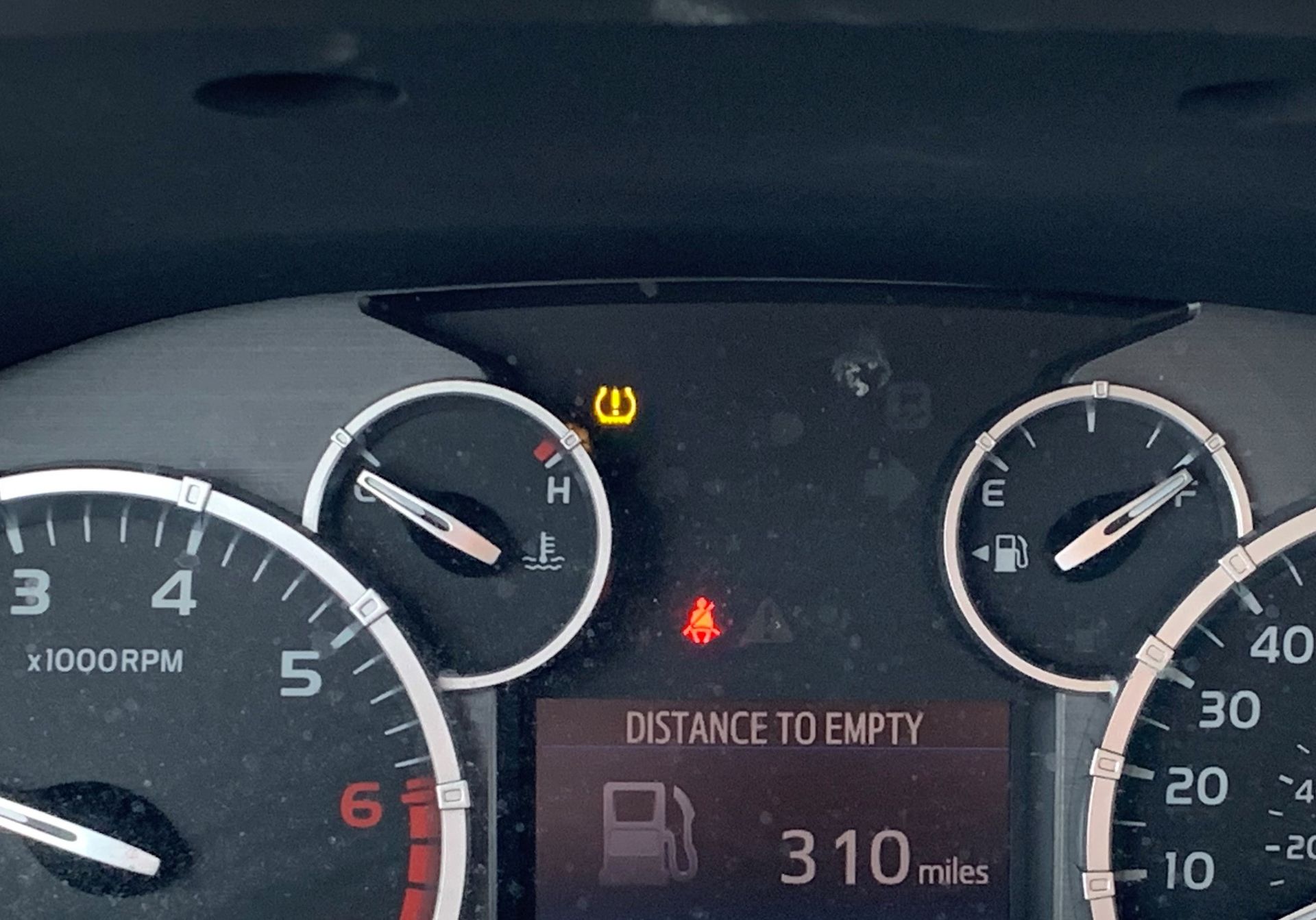 A car dashboard shows the distance to empty is 310 miles | Lou's Car Care Center Inc.