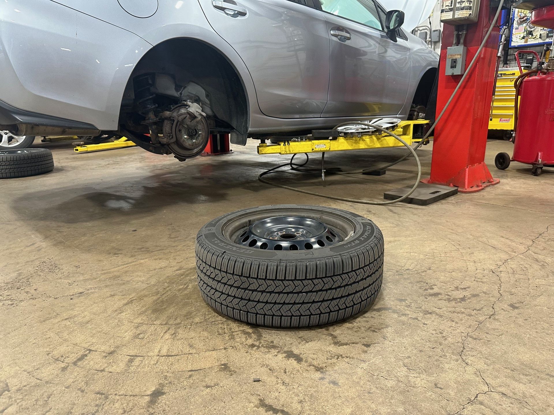 Tire on shop floor on side of vehicle | Lou's Car Care Center, Inc.