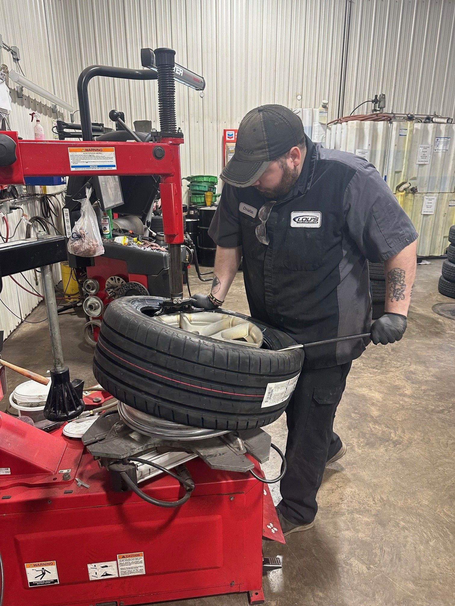 Technician replacing tire on wheel rim | Lou's Car Care Center, Inc.