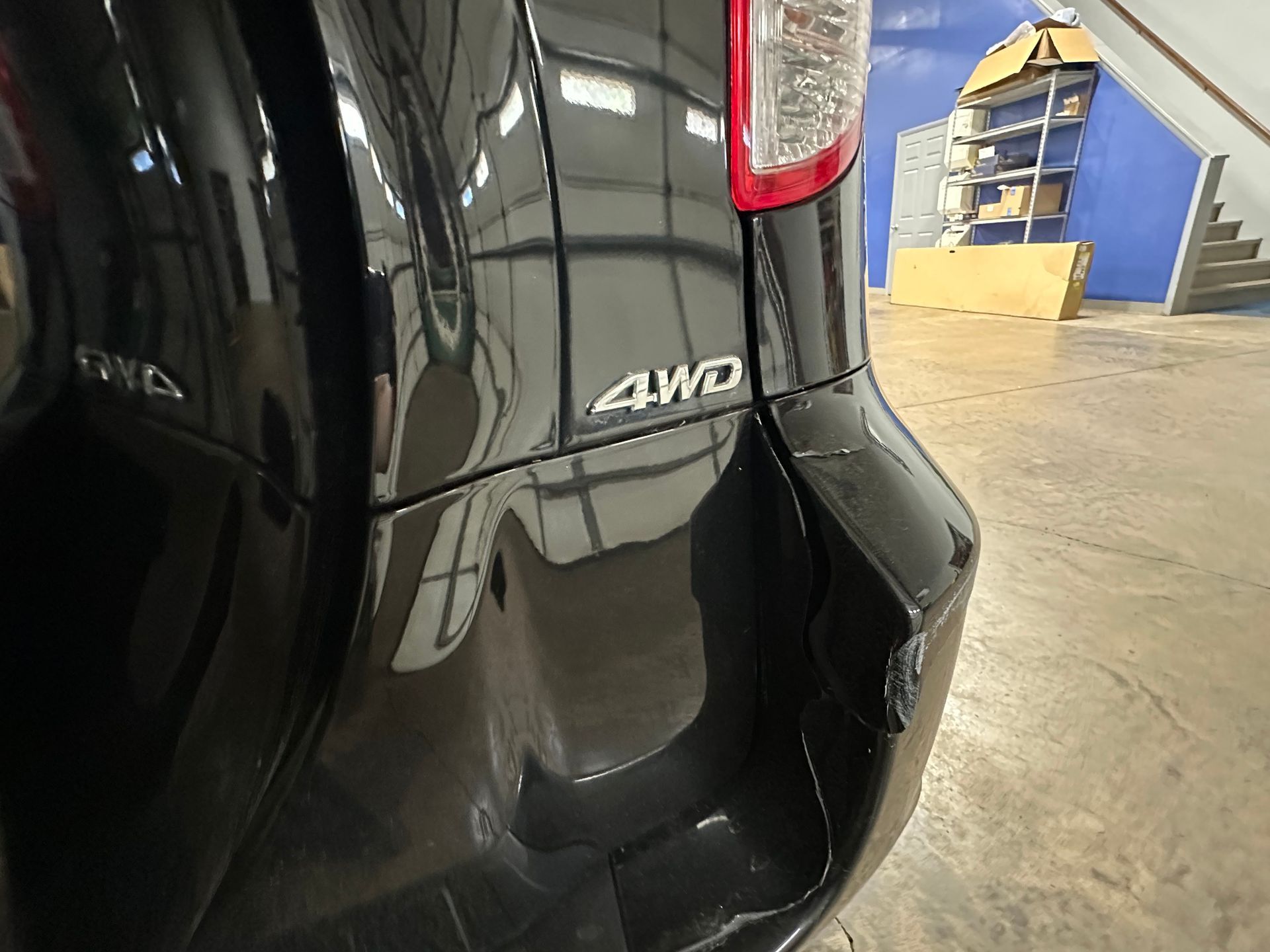 A black 4wd car is parked in a garage. | Lou's Car Care Center Inc.