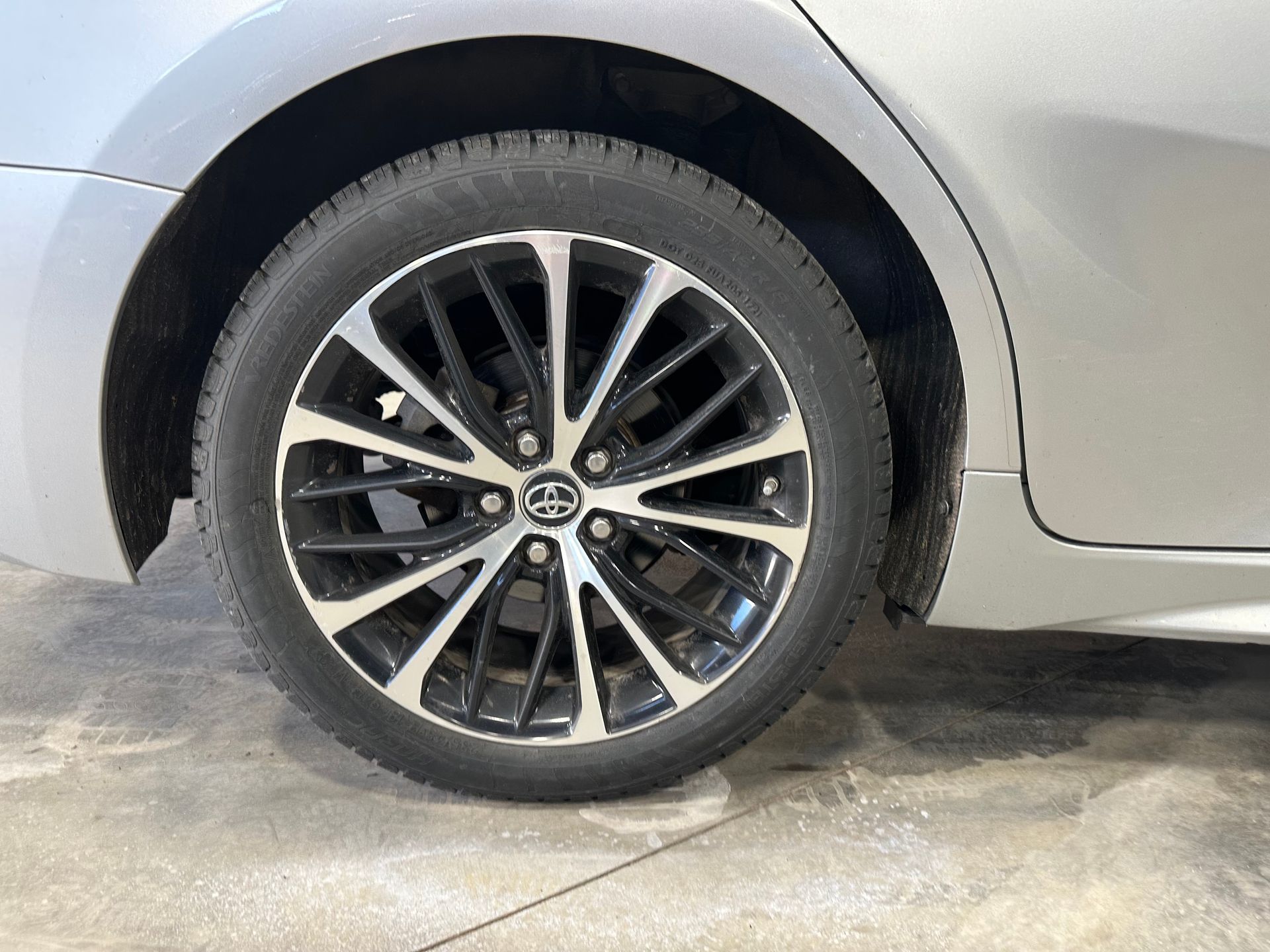 A close up of a car wheel on a concrete surface. | Lou's Car Care Center Inc.