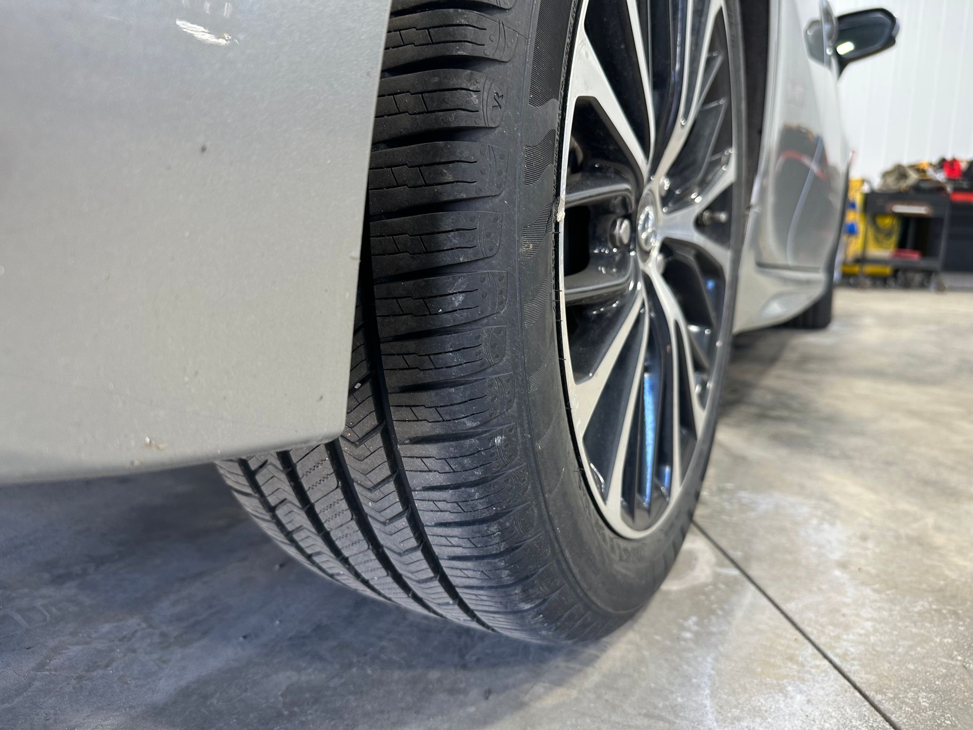 A close up of a car tire in a garage. | Lou's Car Care Center Inc.