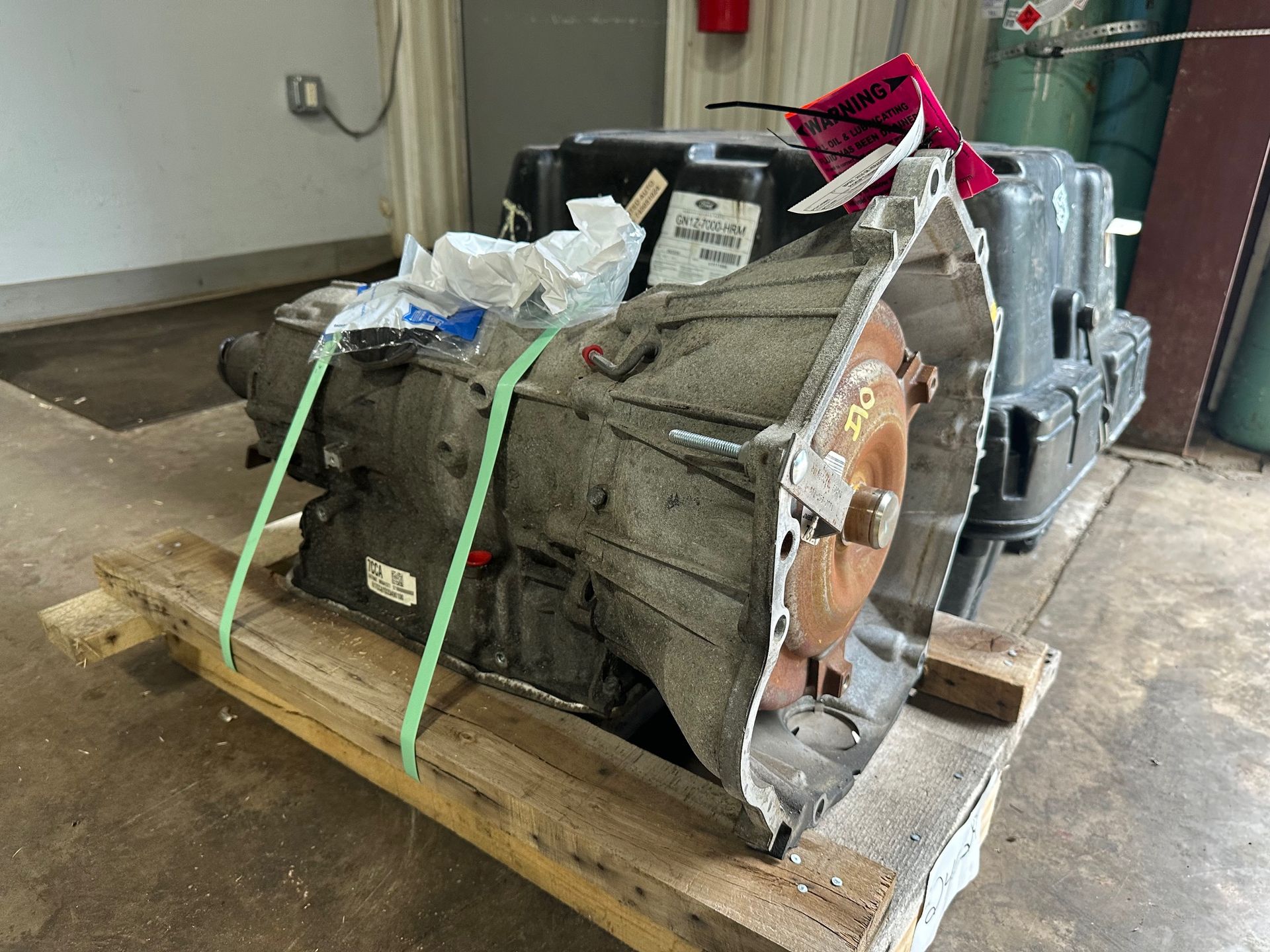 A gearbox is sitting on a wooden pallet in a garage.  | Lou's Car Care Center, Inc.