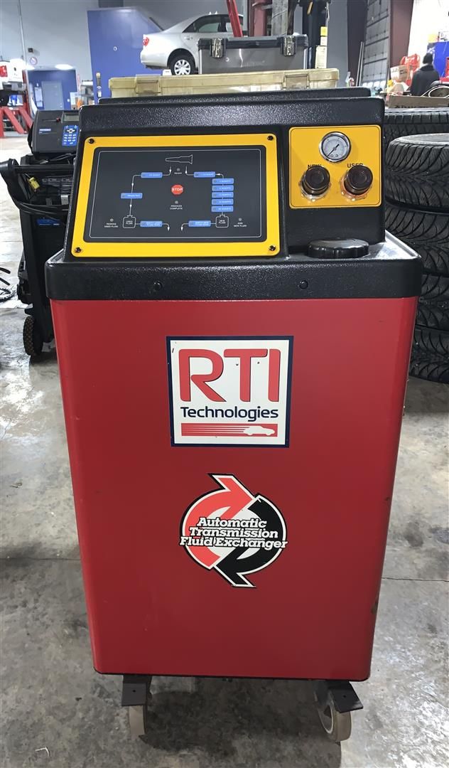 A red and yellow rti machine is sitting in a garage.  | Lou's Car Care Center, Inc.