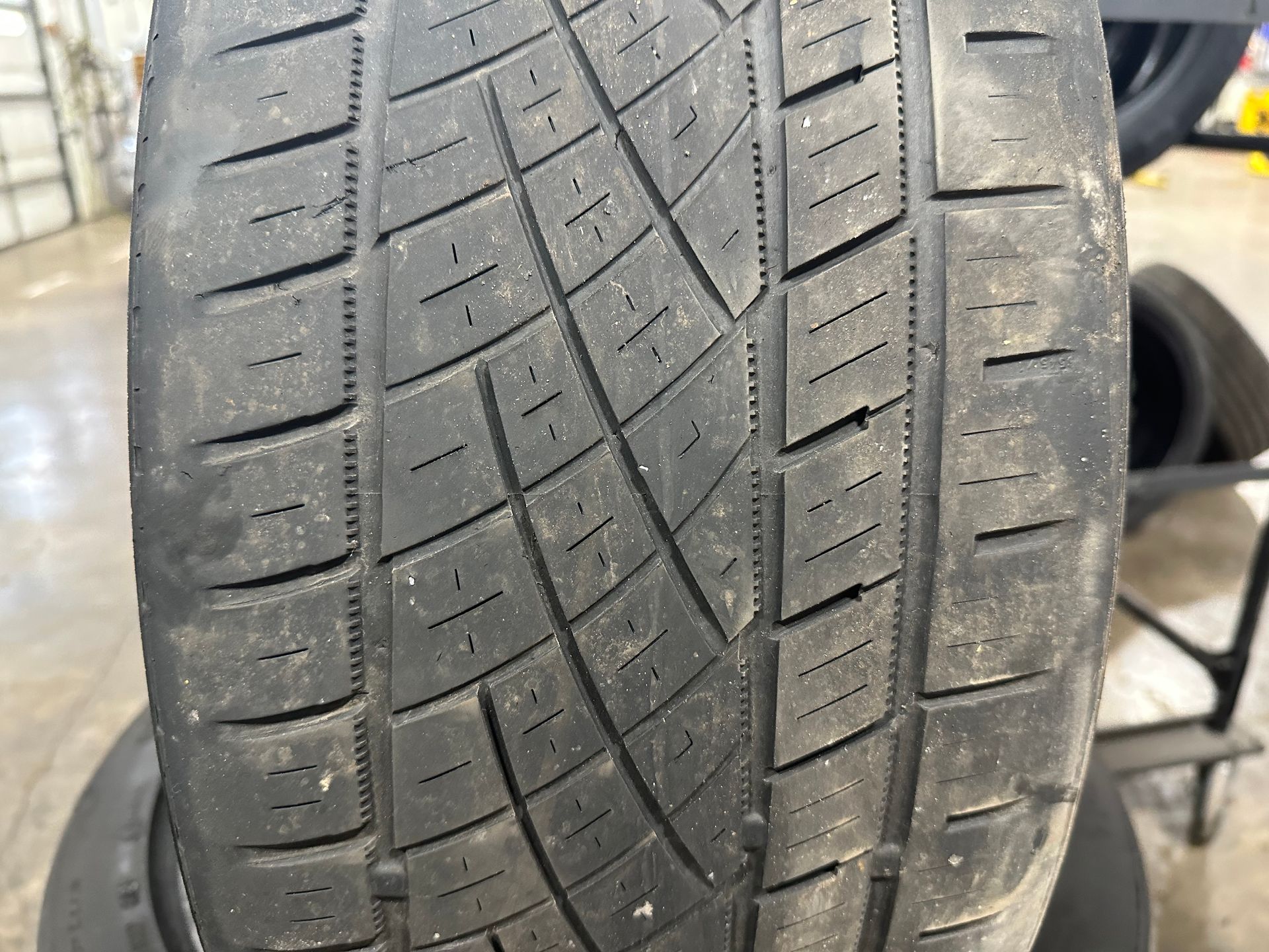 A close up of a tire on a stack of tires. | Lou's Car Care Center Inc.