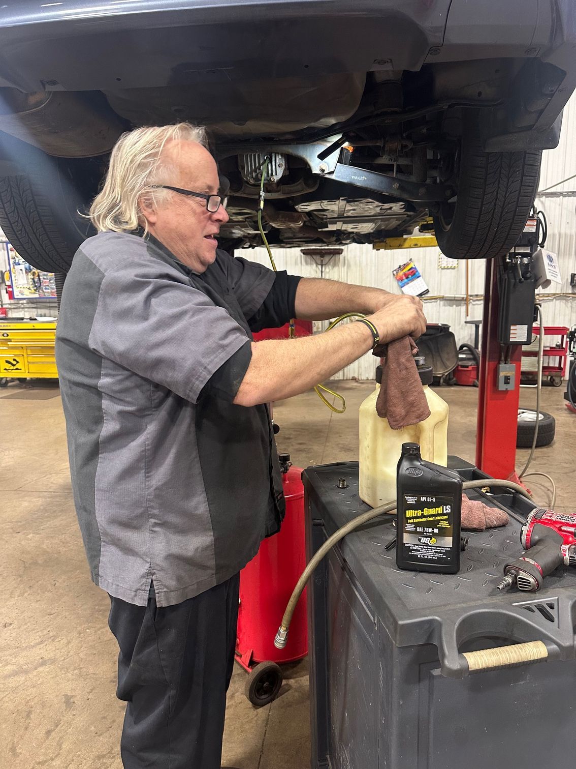 Technician performing differential service on a vehicle.