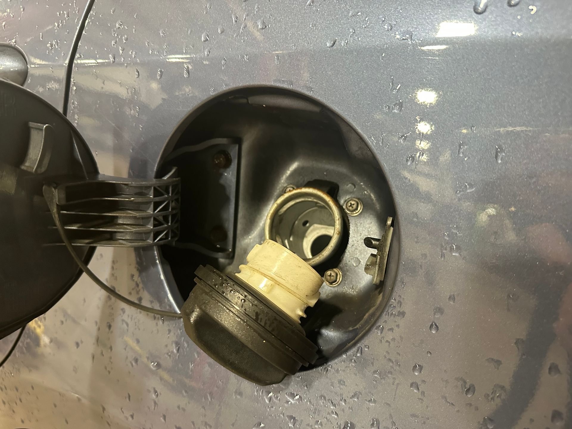 Loose vehicle gas cap on silver car in the shop | Lou's Car Care Center, Inc.