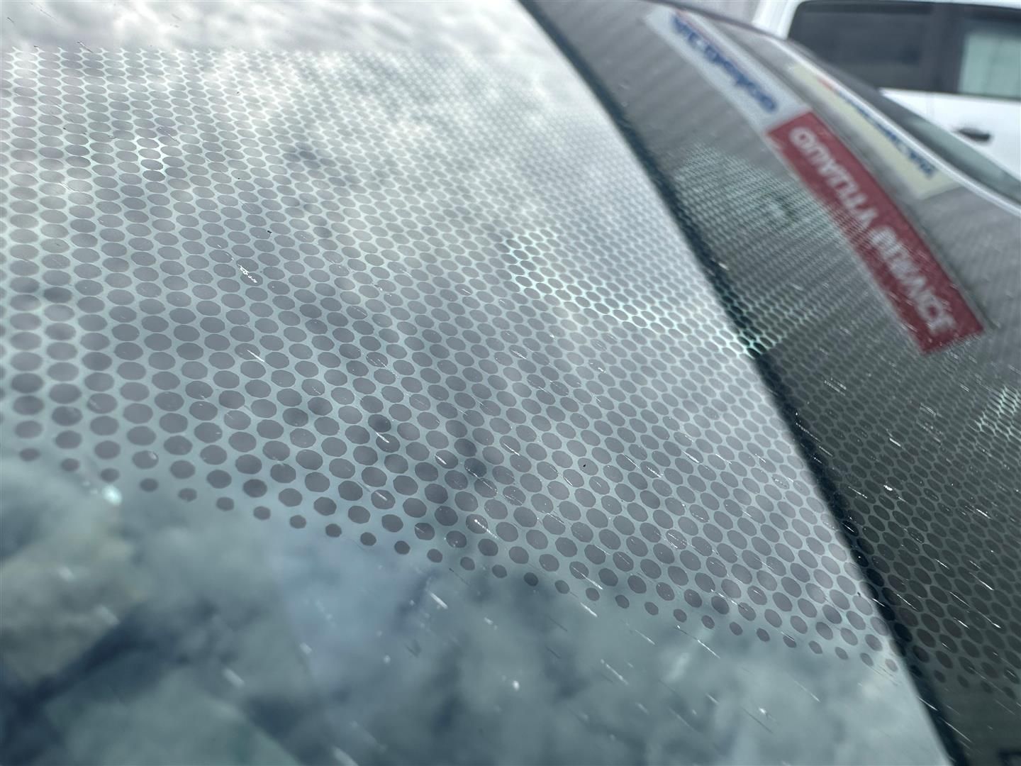 A close up of a car windshield with a sticker on it | Lou's Car Care Center, Inc.