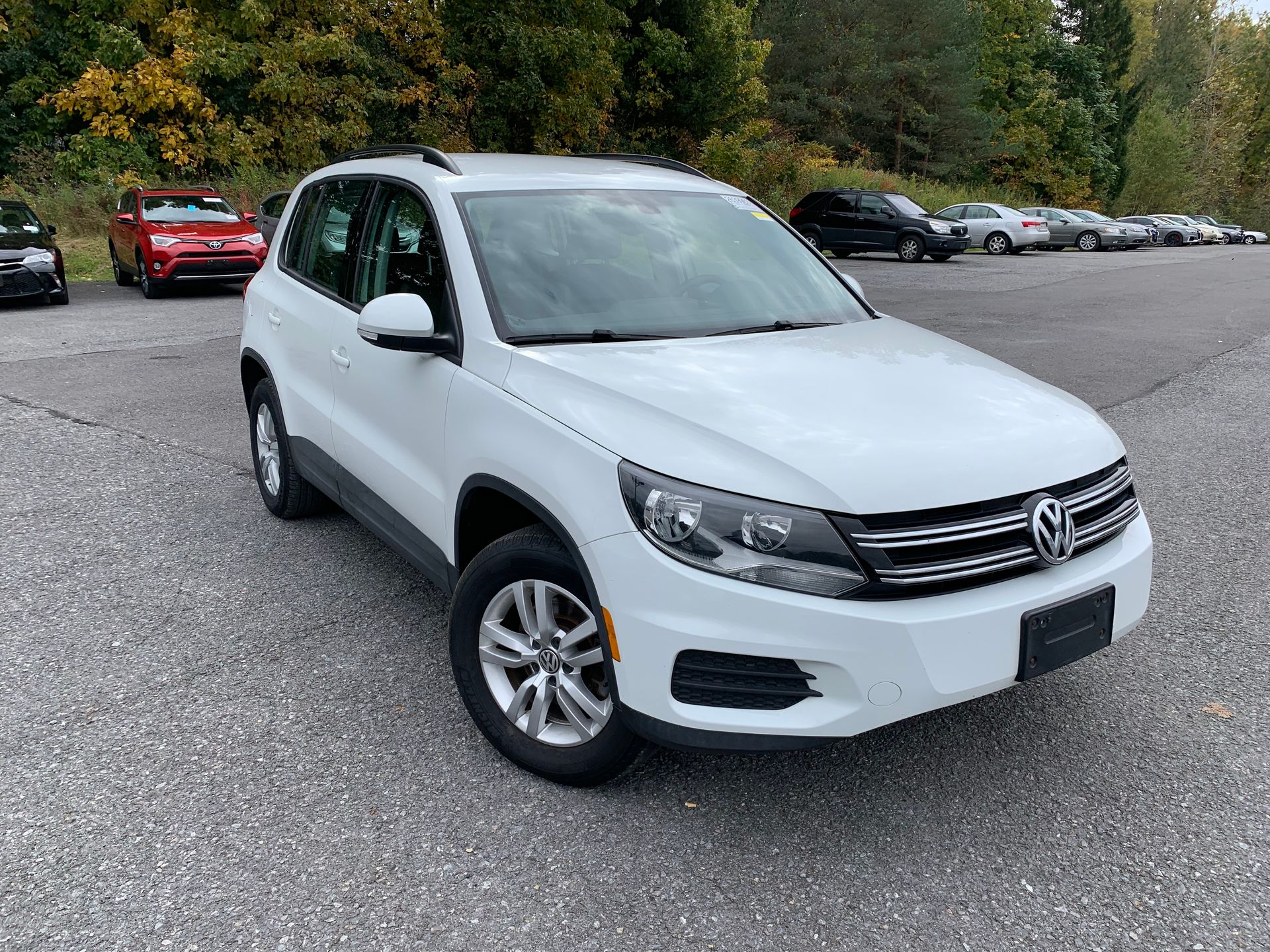 A white volkswagen tiguan is parked in a parking lot. | Lou's Car Care Center, Inc.