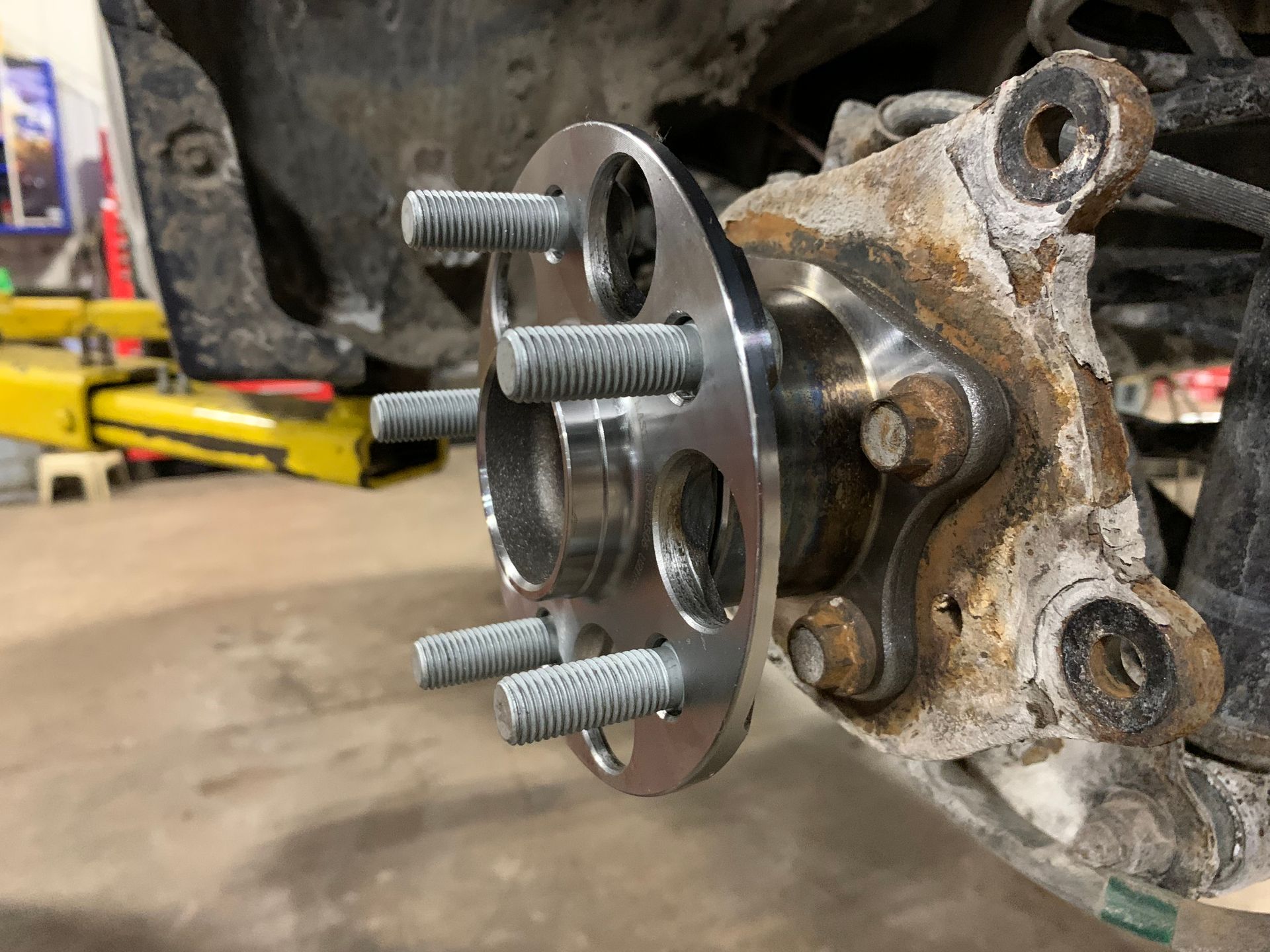 A close up of a wheel hub on a car in a garage. | Lou's Car Care Center, Inc.