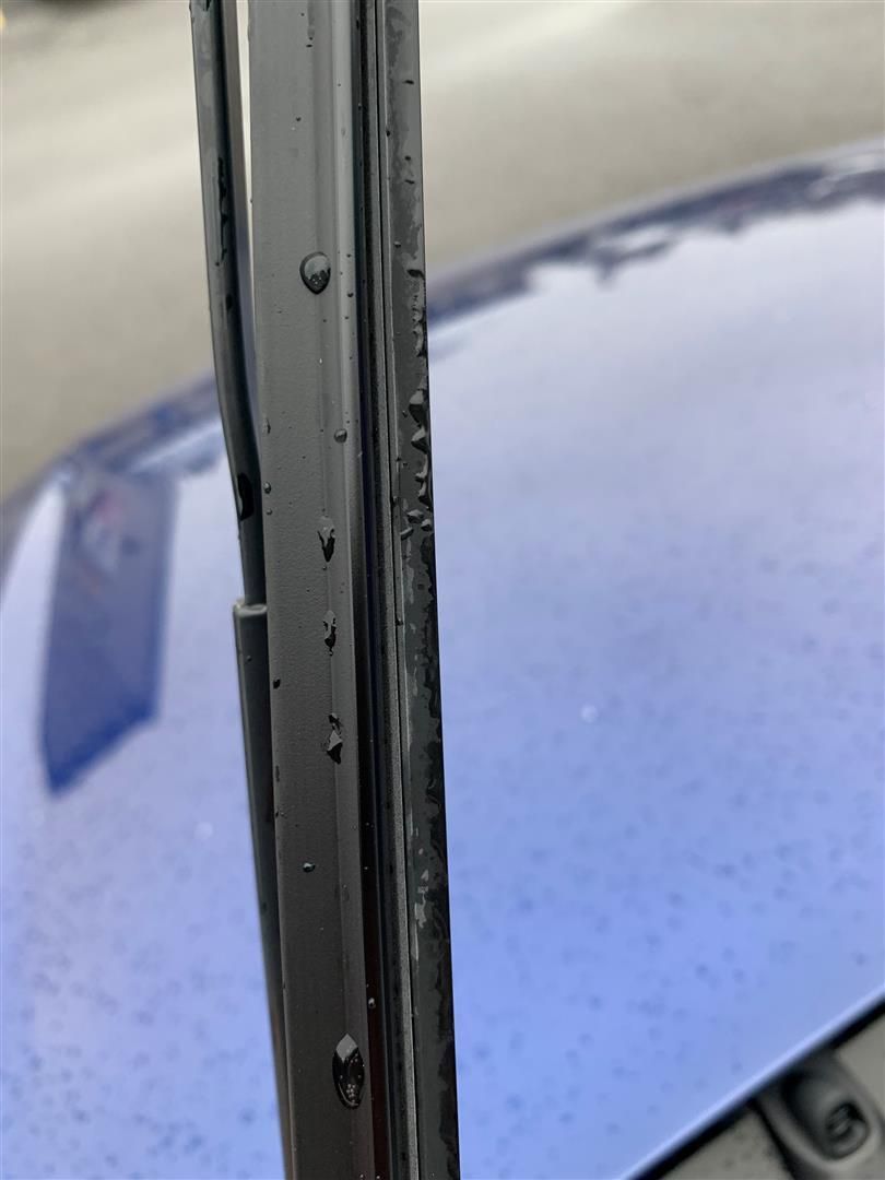 A close up of a wiper blade on a blue car. | Lou's Car Care Center Inc.