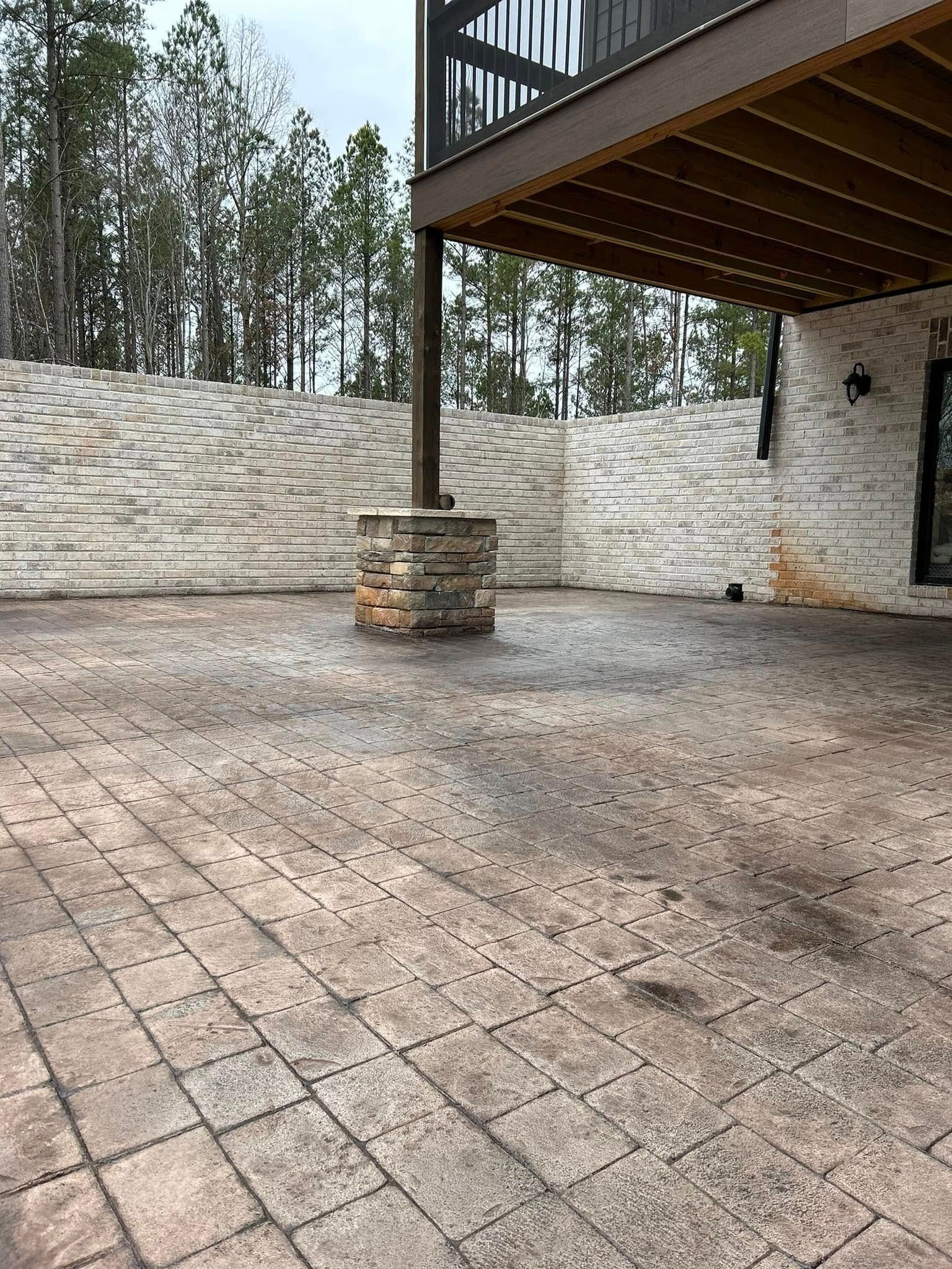 Patio with stone pavers, fire pit, and stairs leading up. Deck overhead.