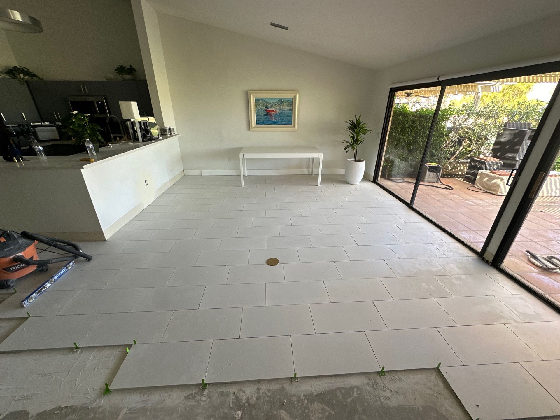 Interior room with light gray tile flooring being installed