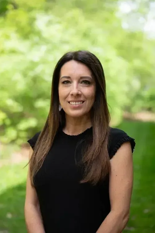The woman is wearing a black shirt and smiling for the camera.