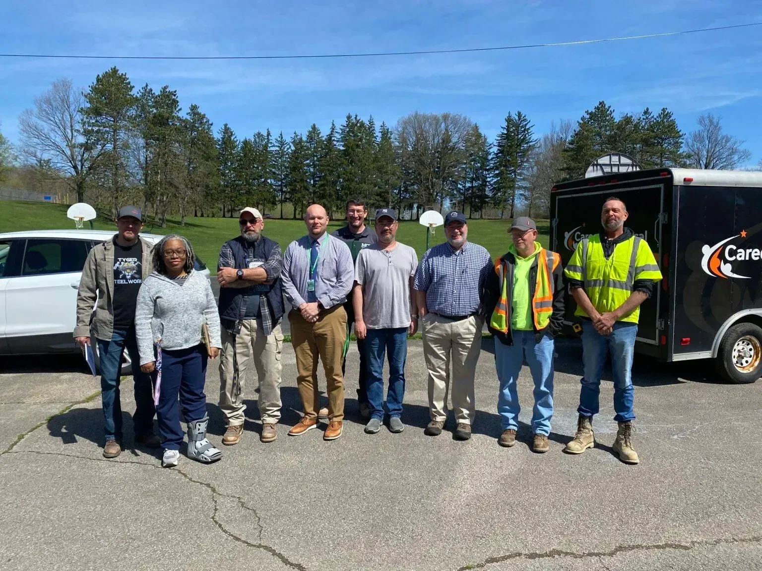 A group of people standing next to each other in front of a truck.