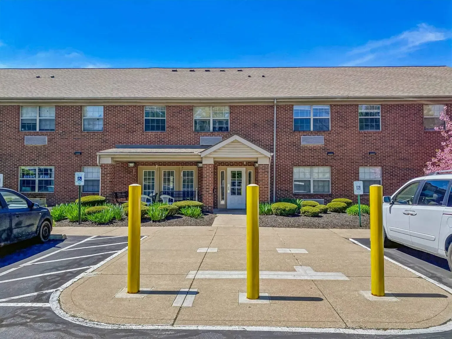 A brick building with a parking lot in front of it.