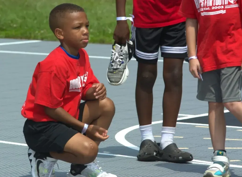 A boy in a red shirt that says ' iowa ' on it