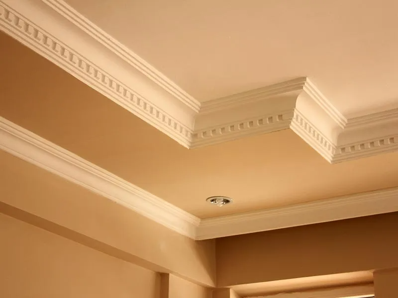 Beige room corner with white crown molding.