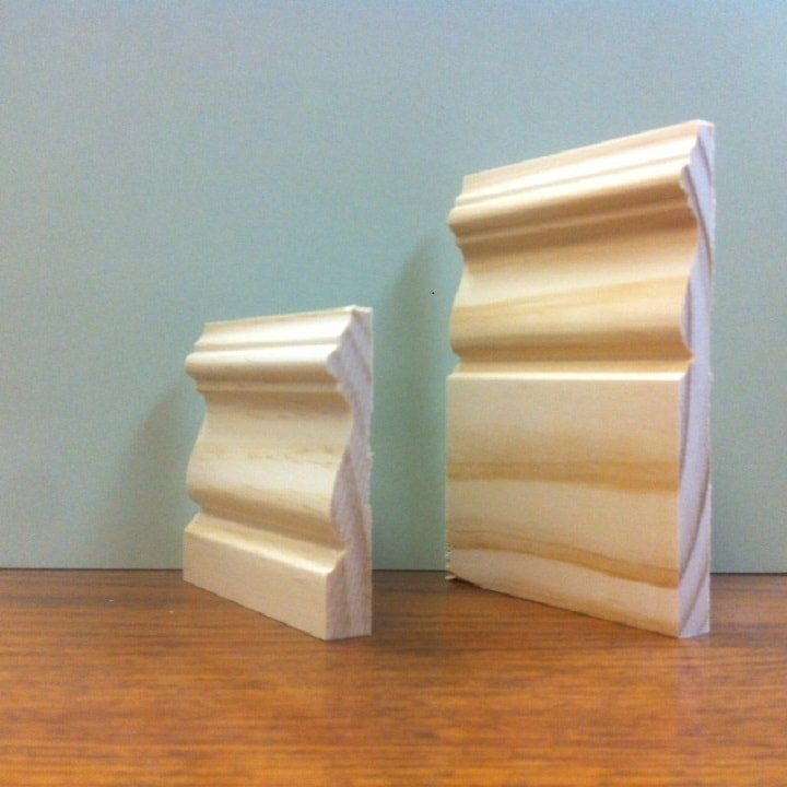 Two wooden crown molding samples on a table.