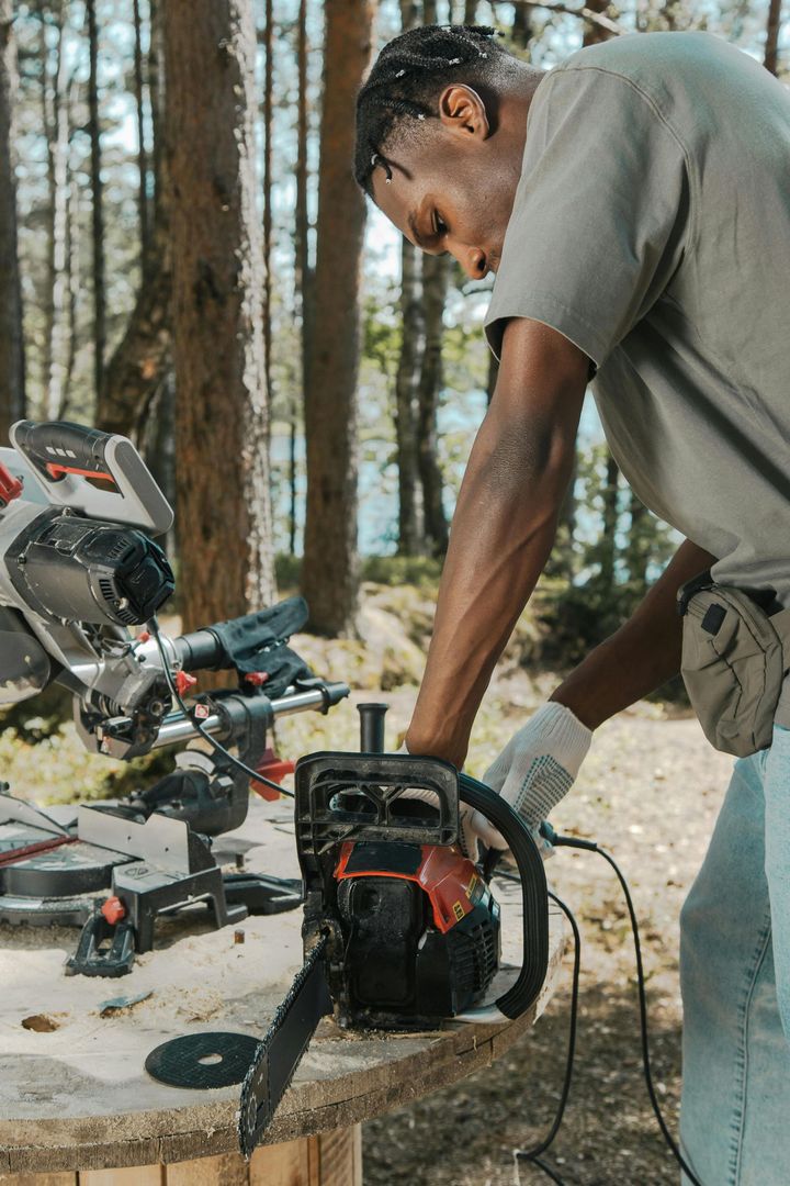 A man is using a chainsaw to cut a piece of wood.