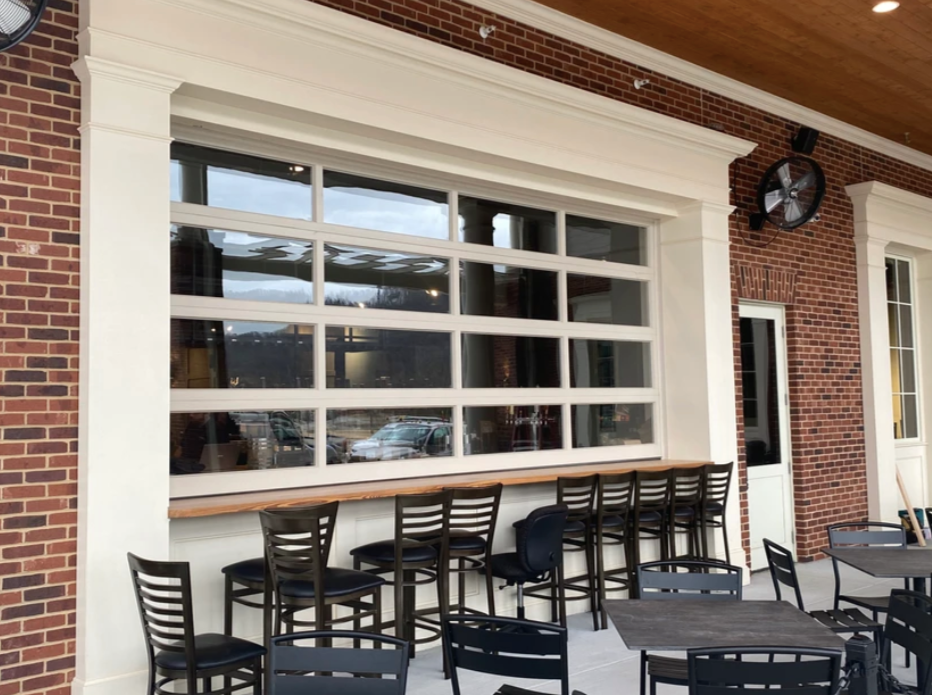 A restaurant with tables and chairs and a large window