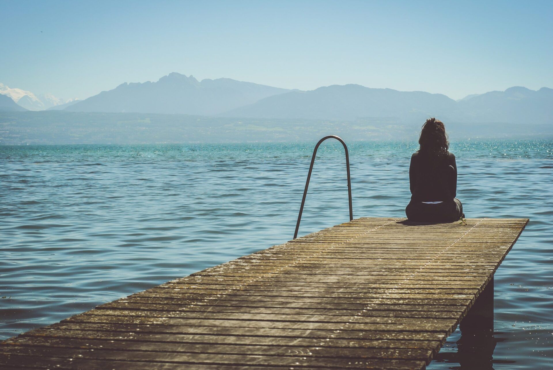 woman sitting alone on dock why successful people commit suicide