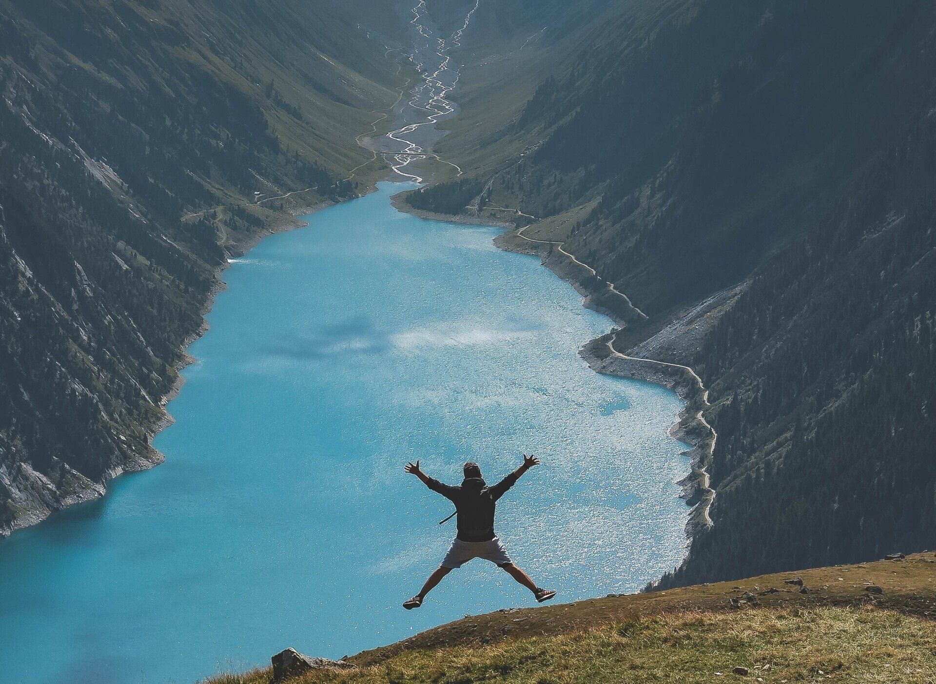 man jumping for joy in front of lake for learning to manage OCD