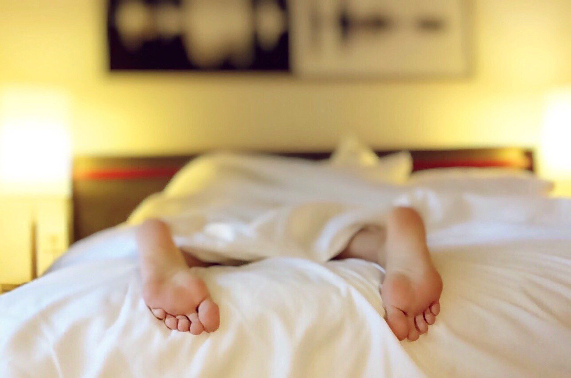 person's feet sticking out of covers because of adrenal fatigue