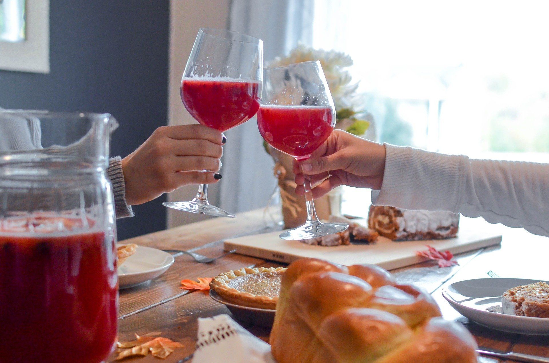people toasting red drink at Thanksgiving table