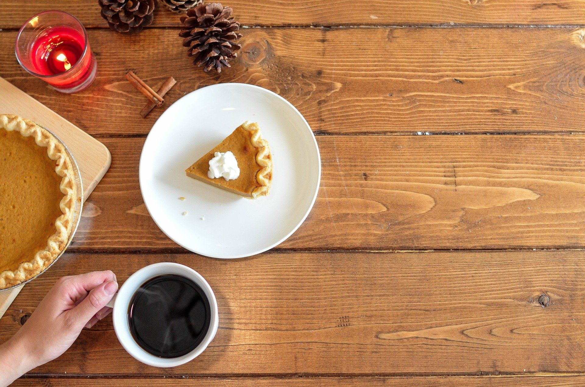 pumpkin pie and cup of coffee on wooden table for Thanksgiving foods