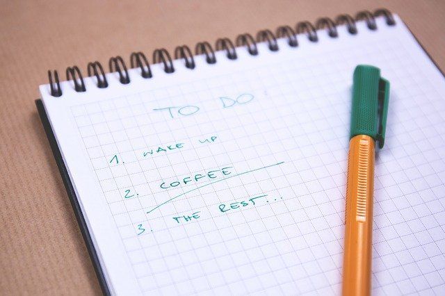 pen on top of pad of paper with to do list helps get things done despite anxiety