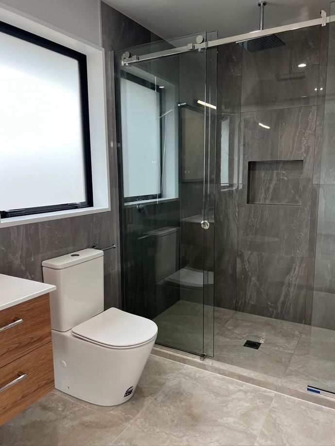 a bathroom with a toilet and a walk in shower .