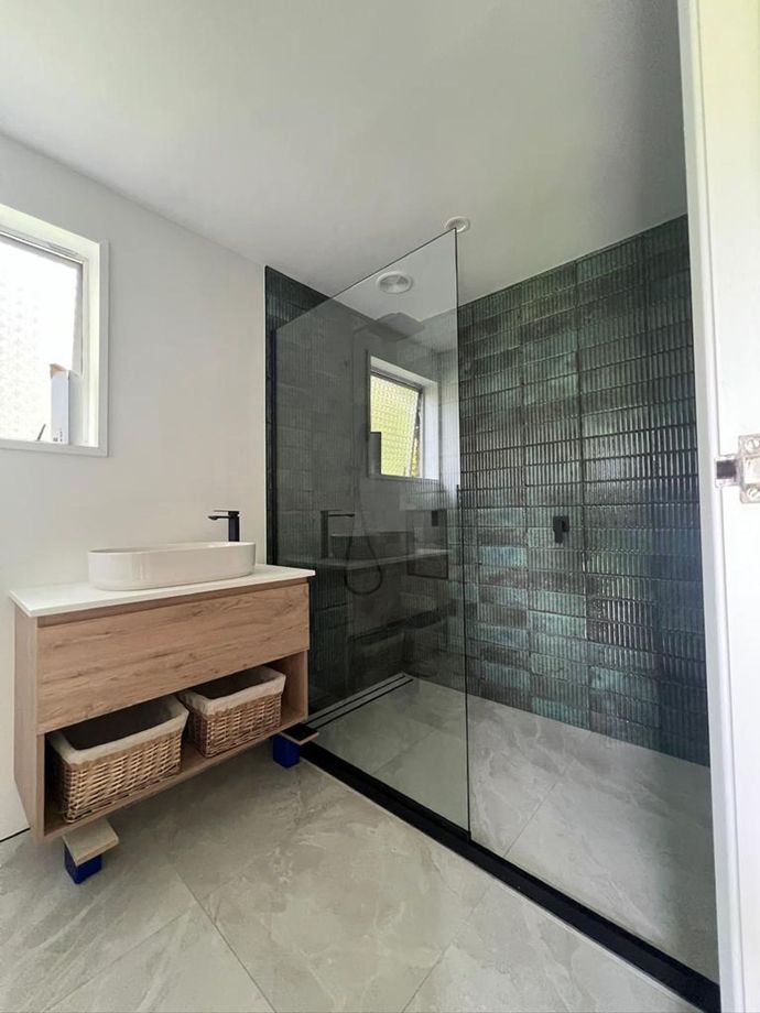 a bathroom with a sink and a walk in shower .