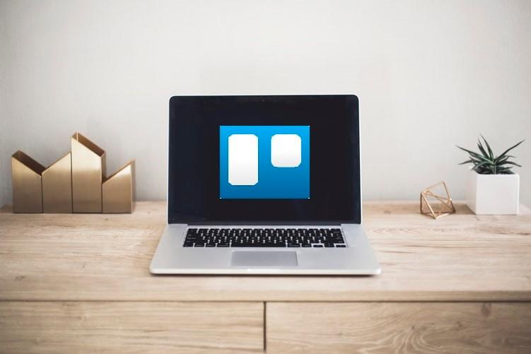 A laptop computer is sitting on a wooden desk.