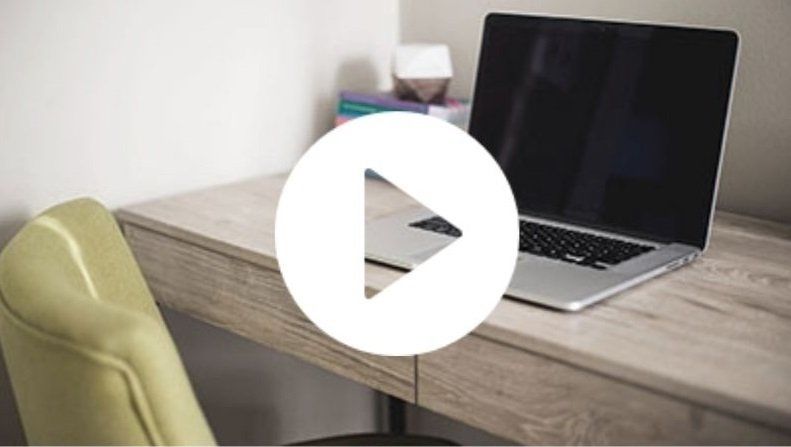 A laptop computer is sitting on a wooden desk.