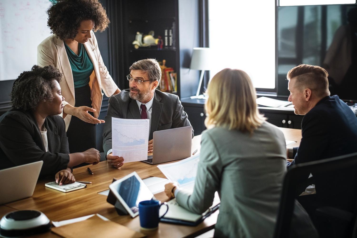 A group of people are sitting around a table having a meeting.