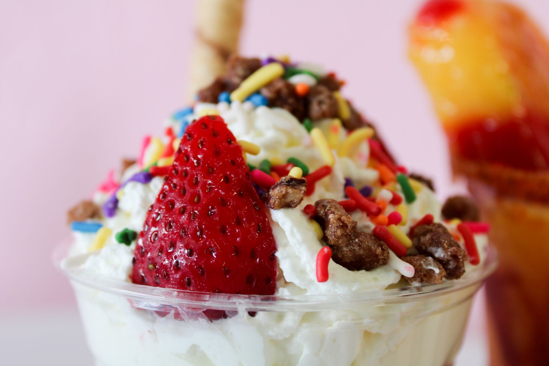 Ice cream sundae with sprinkles and a strawberry.