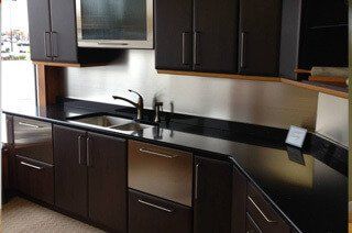 Kitchen design project with dark kitchen cabinets and a black countertop