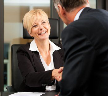 Mature man shaking hands with business woman after meeting