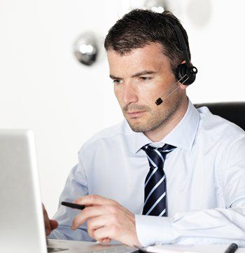Handsome man using an headset in front of a laptop