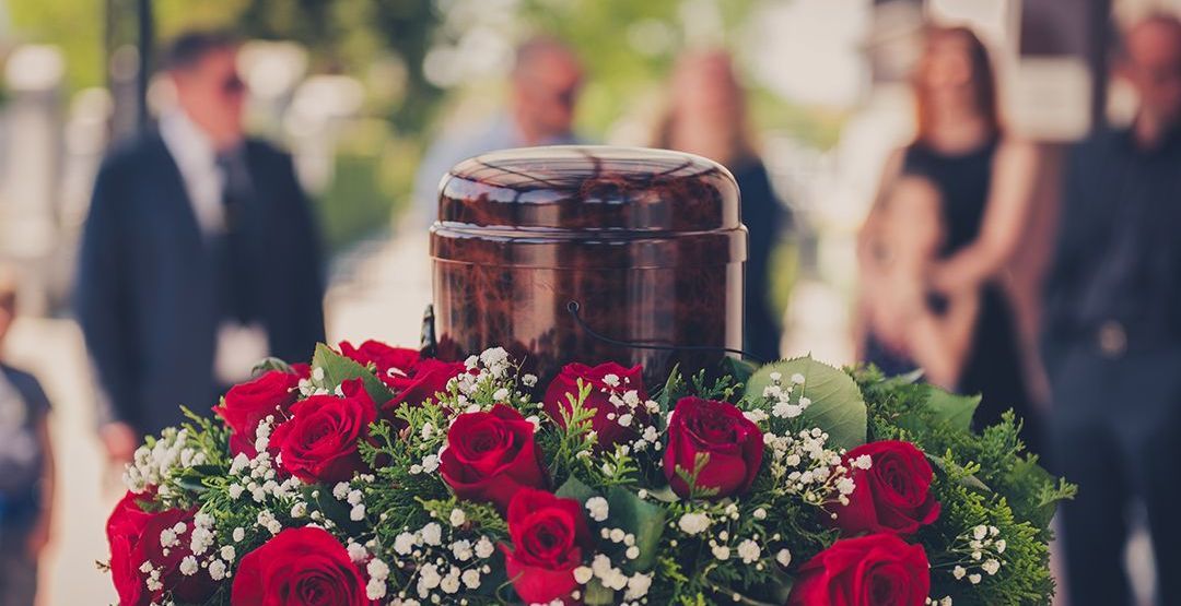 a urn is sitting on top of a wreath of leaves at a funeral .