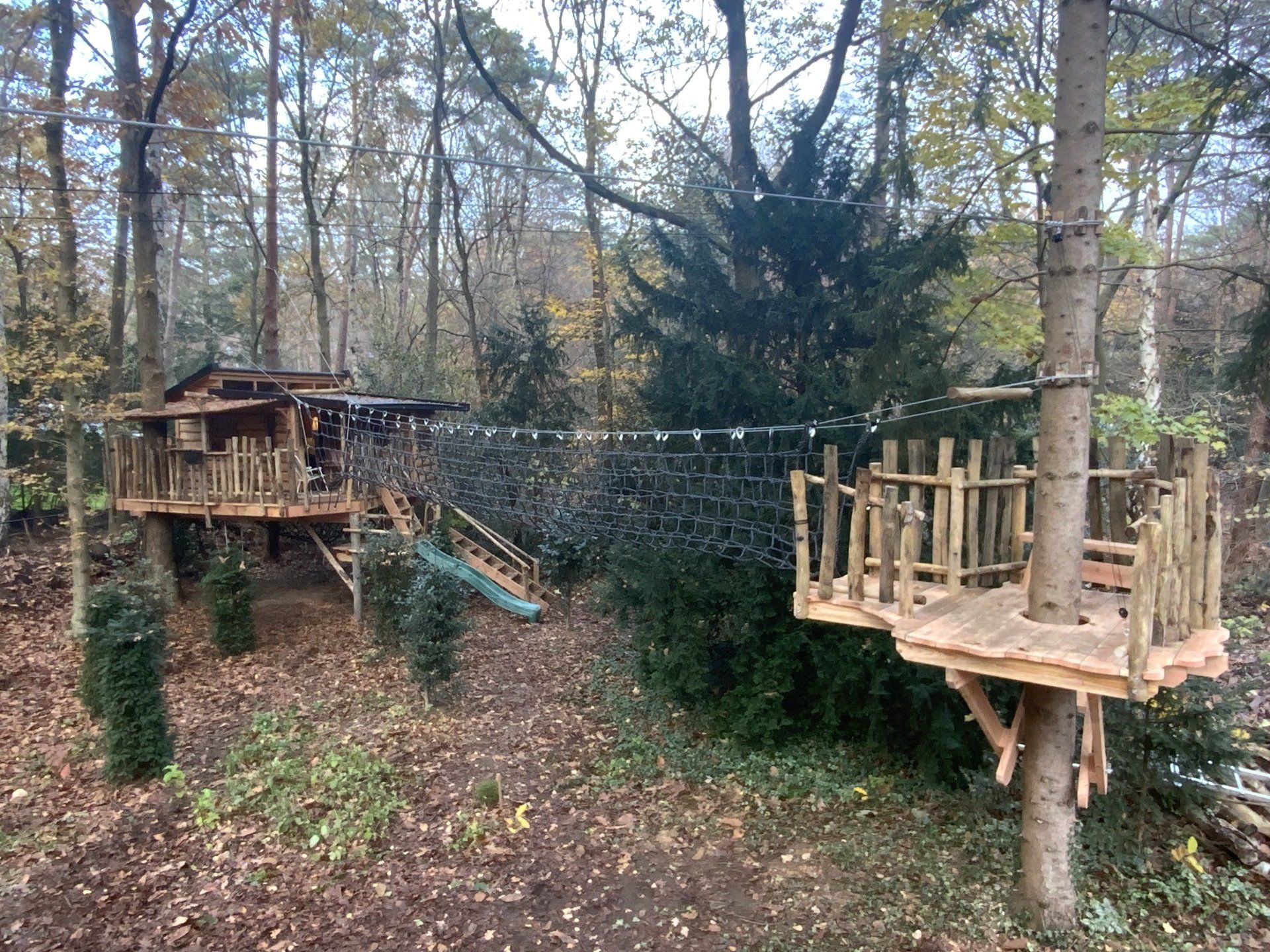 Een houten boomhut midden in een bos.