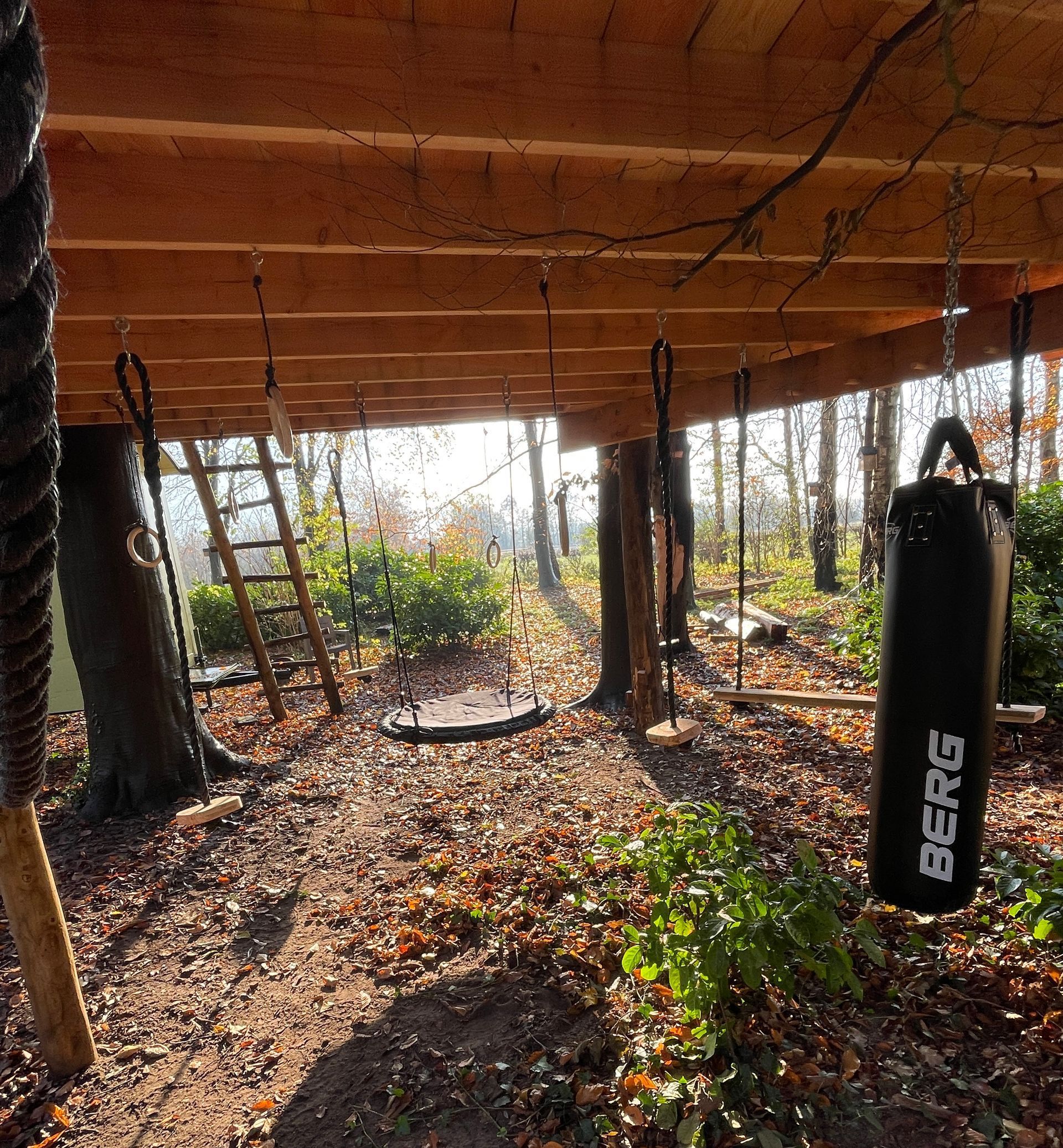 Speelelementen onder de boomhut, bokszak en schommels