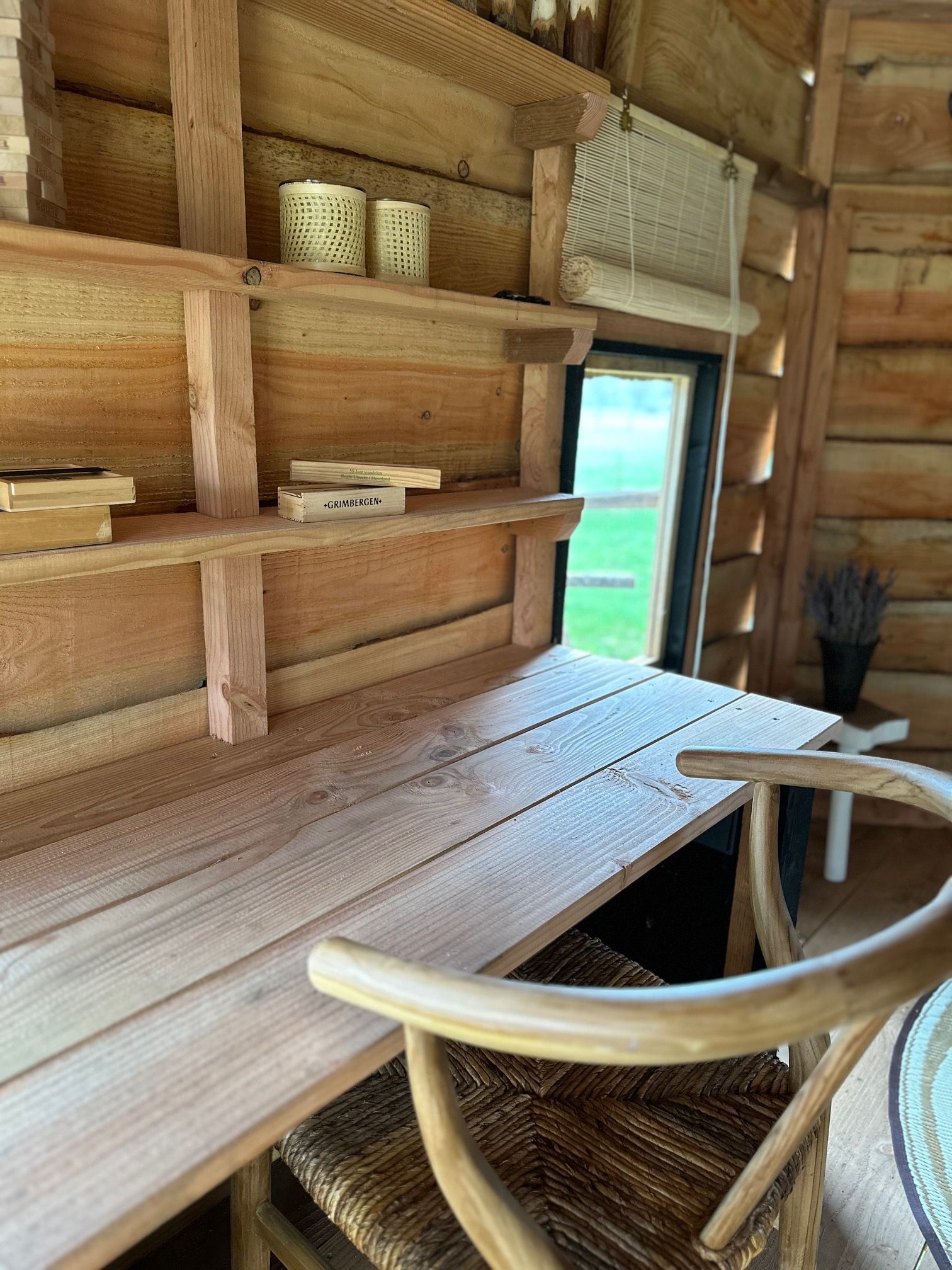 Een houten bureau met stoel in een blokhut.