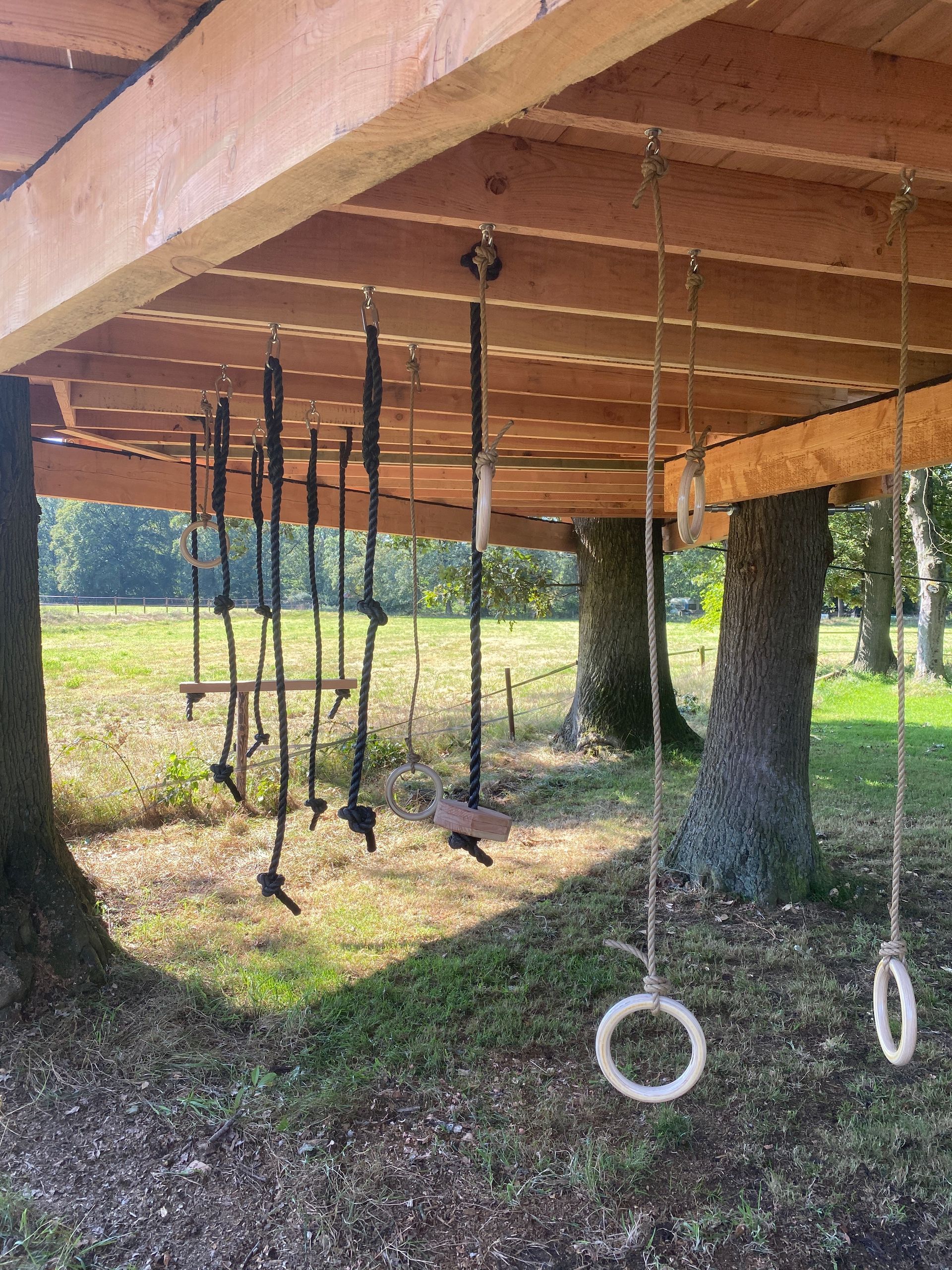 Een houten dek waar touwen en ringen aan hangen.