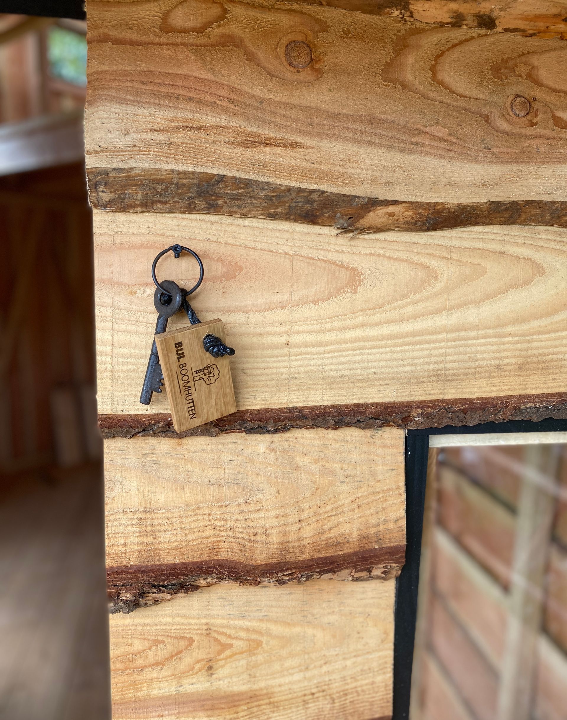 Een paar sleutels die aan een houten muur hangen.
