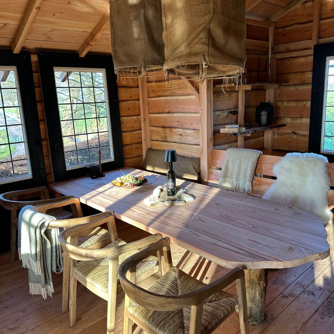 Een houten eetkamer met een tafel en stoelen