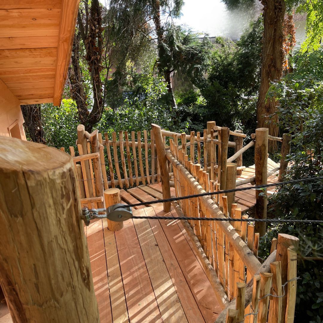 Een houten terras met een hek eromheen in het bos.