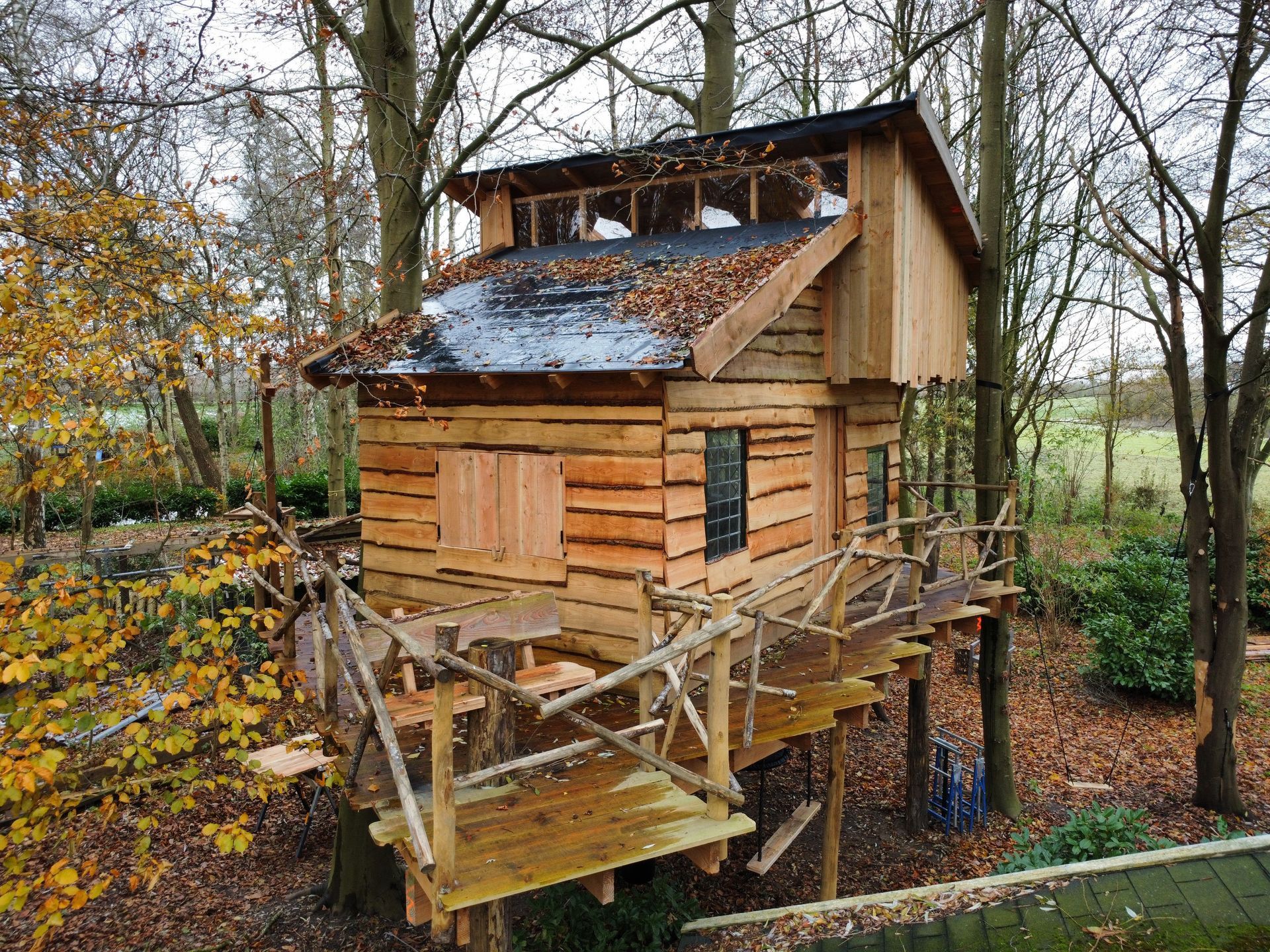 Een kleine houten boomhut midden in een bos.