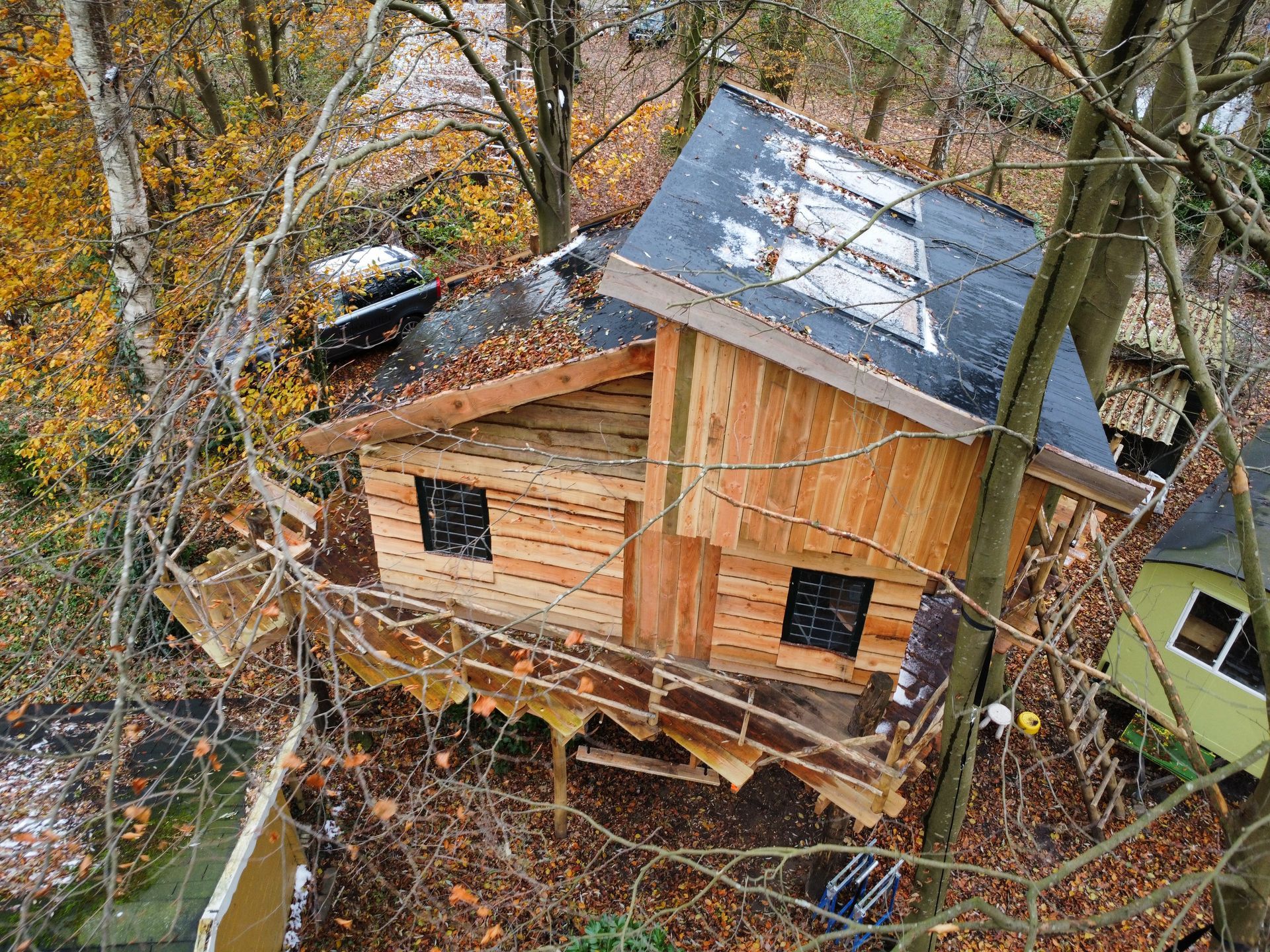 Een luchtfoto van een boomhut midden in een bos.